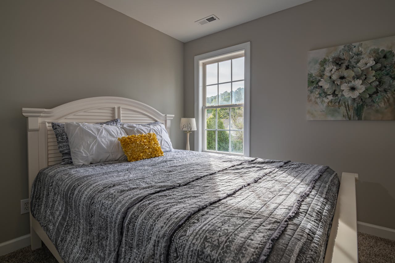 gallery-01 A warm, inviting bedroom with a double bed and natural light streaming in.